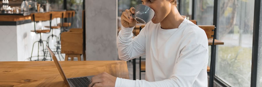A person using a laptop while having coffee E-learning for employees