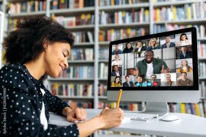 Video call, online education. African American happy female student, learning distantly, watches an online lecture, taking notes, multiracial smiling people on a computer screen, virtual communication